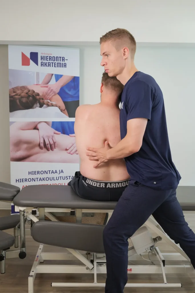 Osteopaatti mobilisoi asiakkaan rintakehää osana hengityksen manuaalista hoitoa.